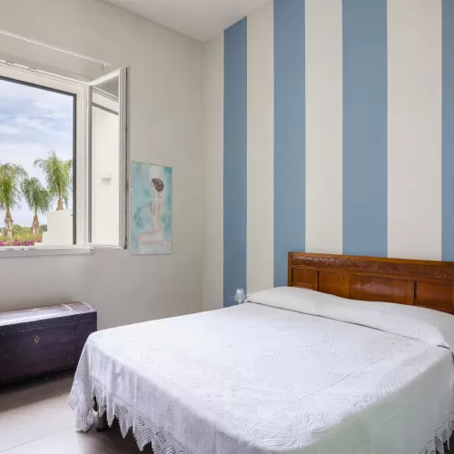 Villa Donna Luigia bedroom with garden view and striped walls